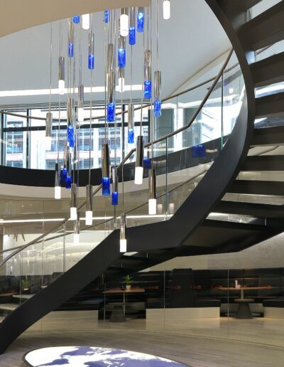 modern open planned bespoke sweeping dark metal and glass staircase